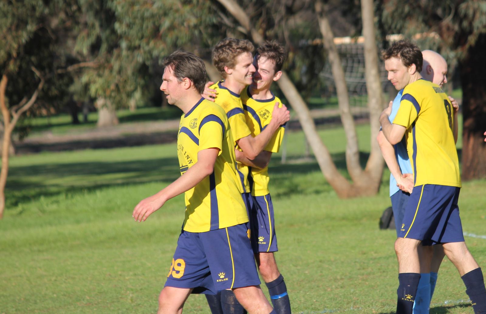 Zak celebrating with teammates on the pitch