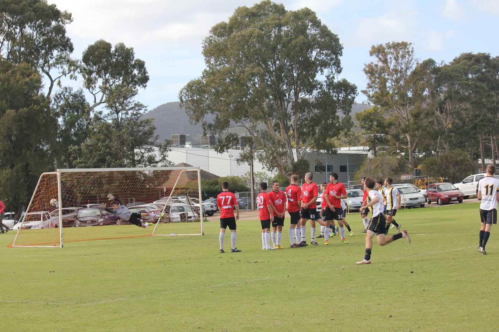 The goalkeeper stretches but can't reach it