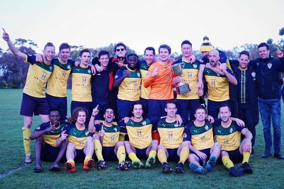 Zak's A's team celebrating a premiership with the trophy
