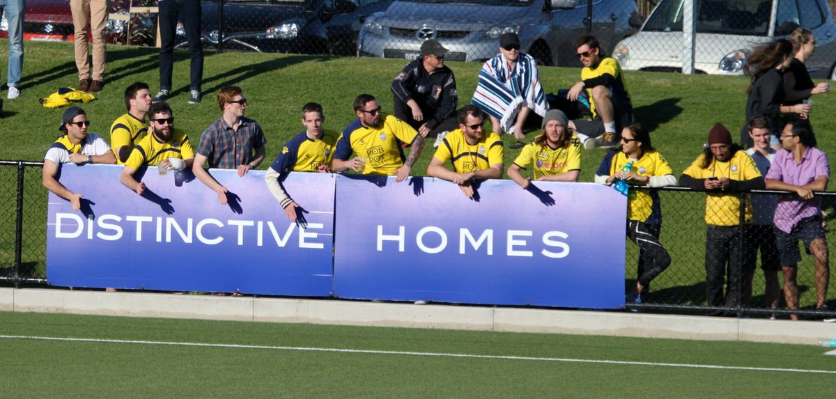 Supporters watching from the sideline fence