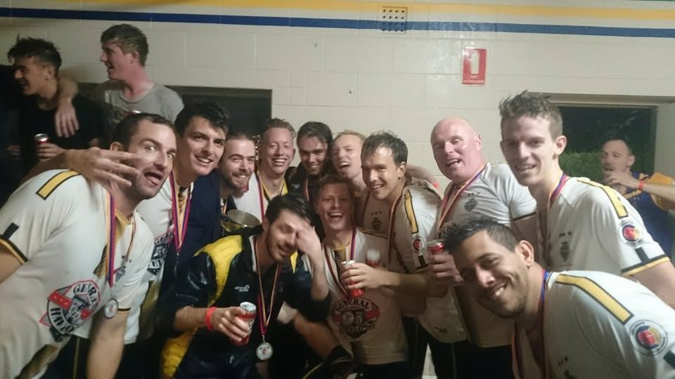 Team celebrating with medals in the change rooms
